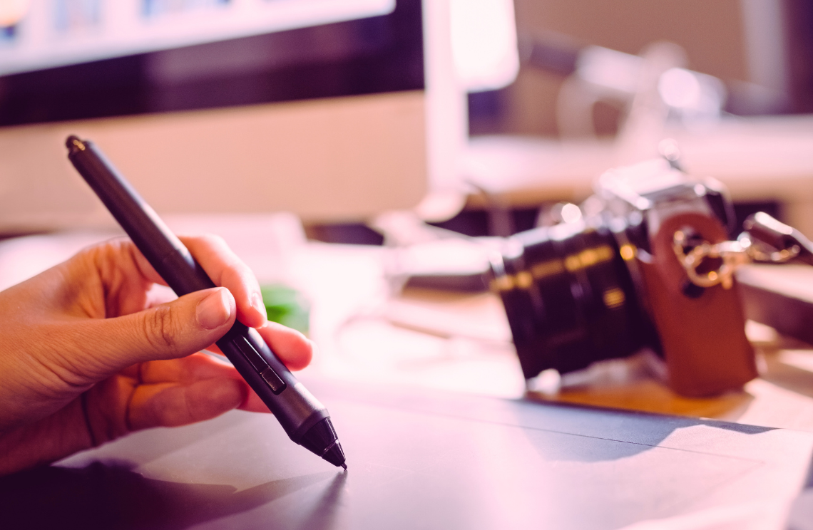 Bureau d'un graphiste : présence d'un ordinateur et d'un appareil photo